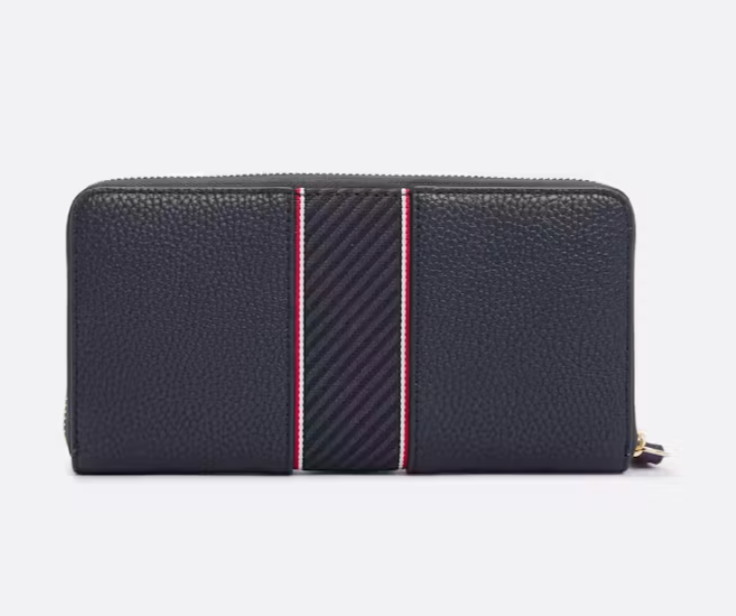 A dark navy pebbled leather zip-around wallet with a central vertical stripe featuring diagonal black and navy pattern flanked by thin red and white borders, shown on a light gray background.
